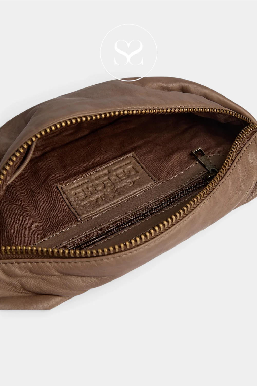 Close-up of an open brown leather pouch or small bag, showing the interior lining, gold-toned zipper, and a branded interior label that reads DESIGNE.