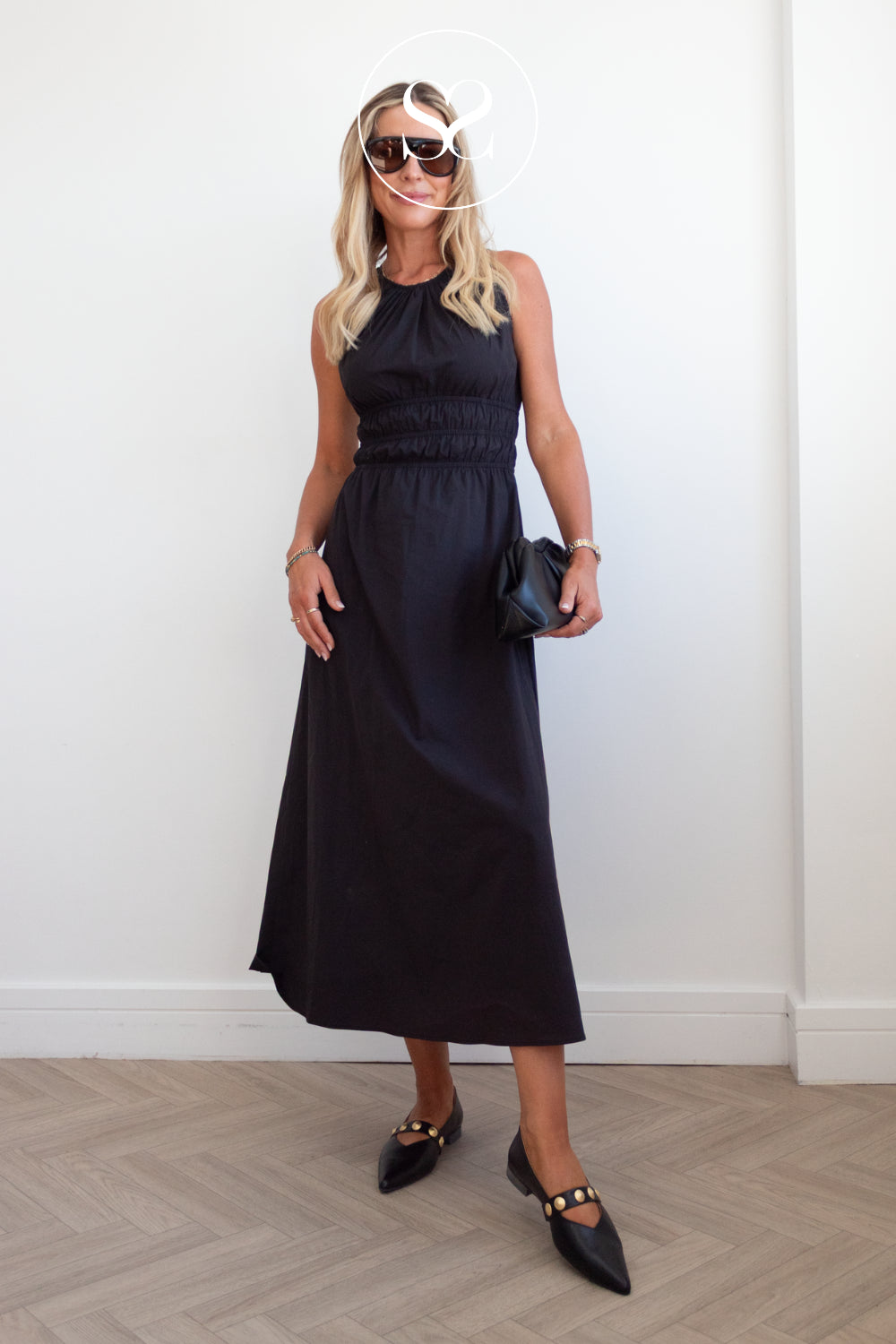 woman wearing dressy pointed toe flats with black dress and sunglassses