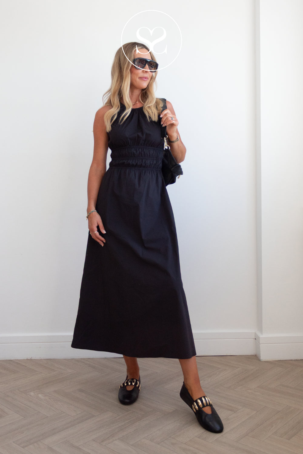 woman wearing comfortable black leather round toe ballet flats with gold details