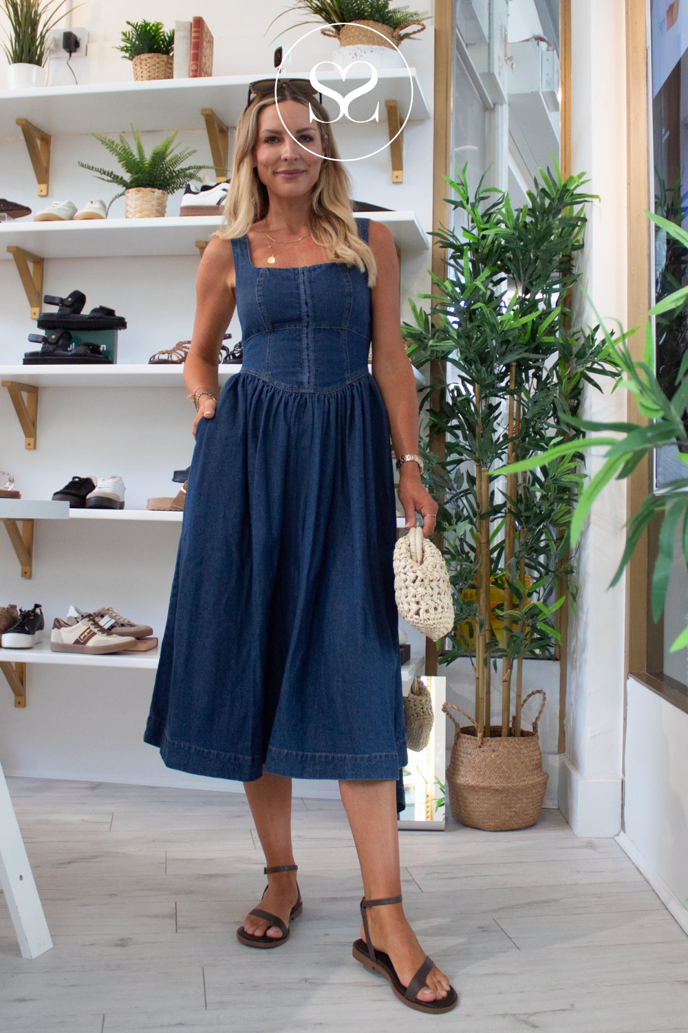 denim dress outfit for summer with dark brown flat sandals, sunglasses and woven clutch bag