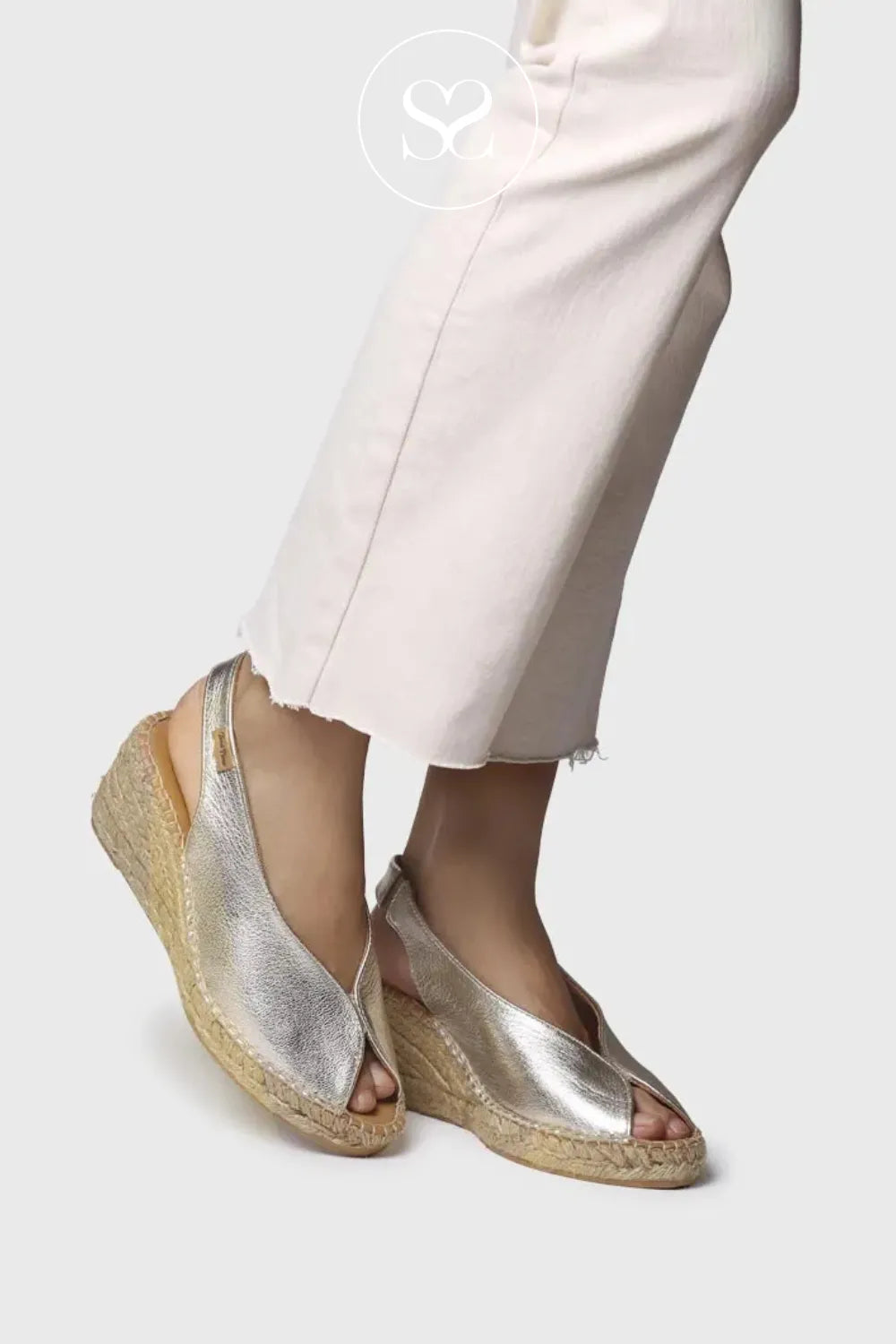 Metallic gold v-cut espadrille sandals. Almond shape toe with peeptoe. Espadrille sole and elasticated slingback strap.
