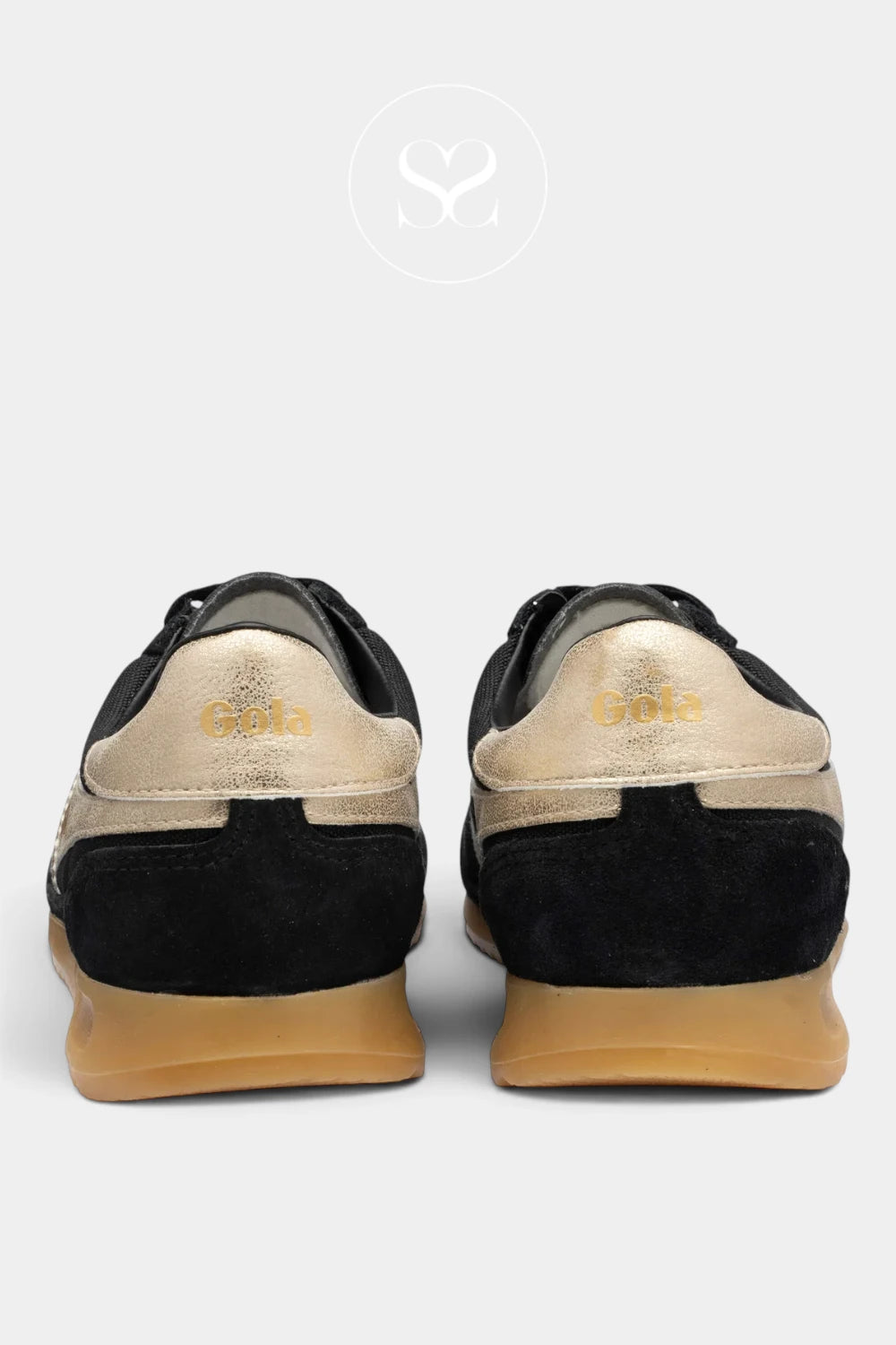 A pair of black and gold sneakers shown from the back, featuring a black suede heel, a metallic gold leather heel counter with 'Gola' branding, and a tan rubber sole, set against a light gray background.