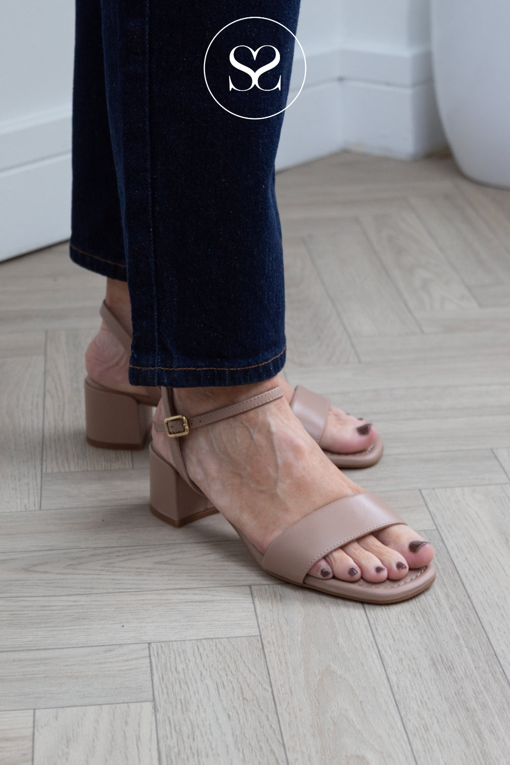 woman wearing comfortable low heel nude leather sandals with barely there straps and cusioning from Unisa