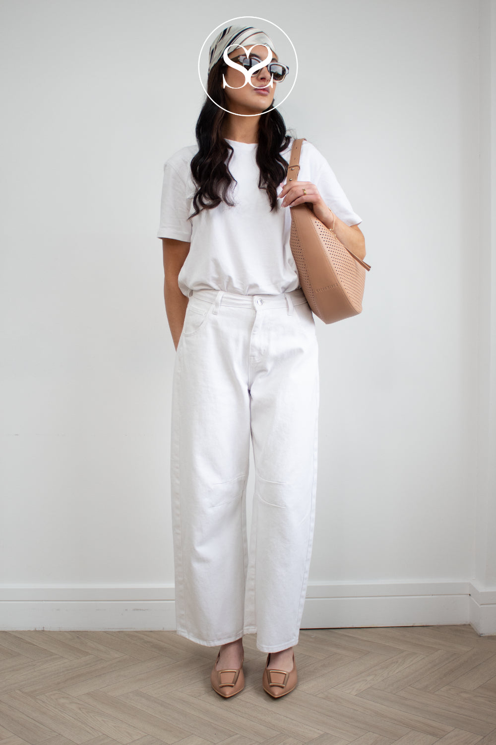 Woman wearing a white outfit with a Hispanitas camel shoulder bag and matching hispanitas camel pointed toe flats with slingback