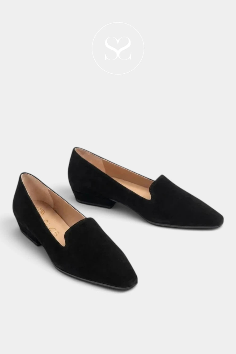 A pair of Unisa black pointed-toe slip-on flats made of black suede, shown from a high angle on a light gray background with a brand logo watermark at the top.