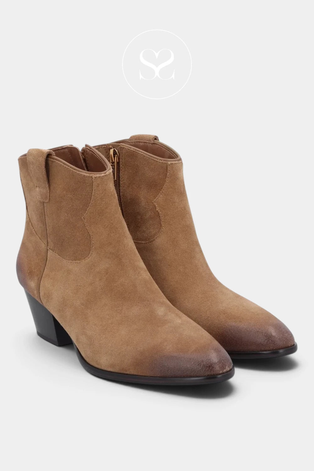 A pair of women's ankle boots in tan suede with a dark brown pointed toe and low block heel, shown on a light gray background with a faint brand logo above.