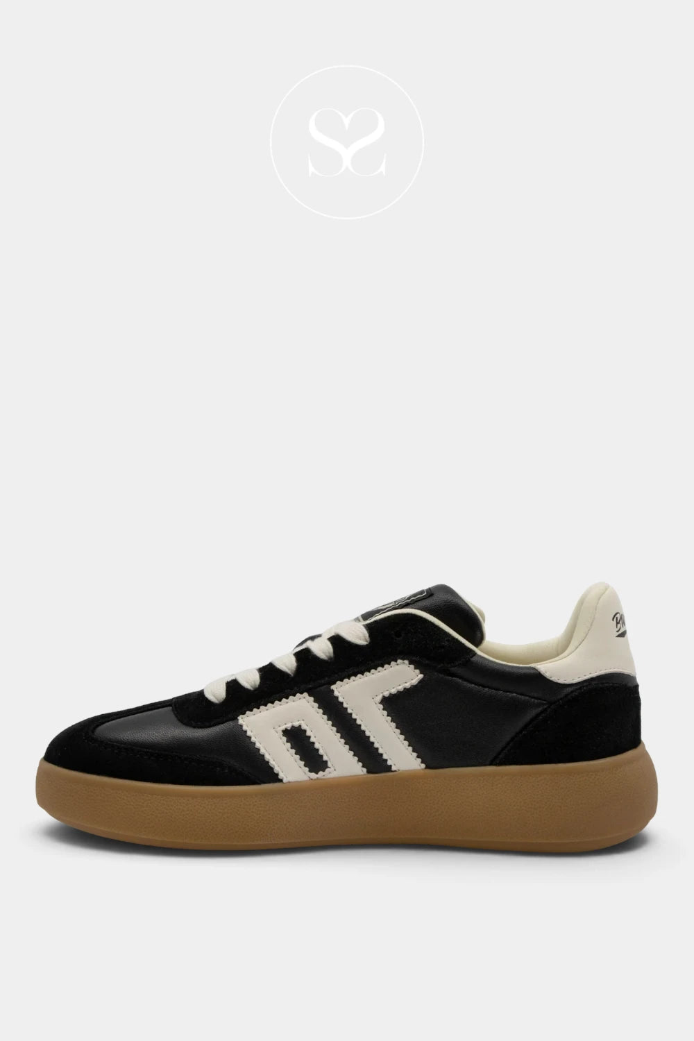 A low-top sneaker in black leather and suede with cream-colored side stripes, cream laces, and a thick gum brown sole, shown from a side profile on a light gray background.