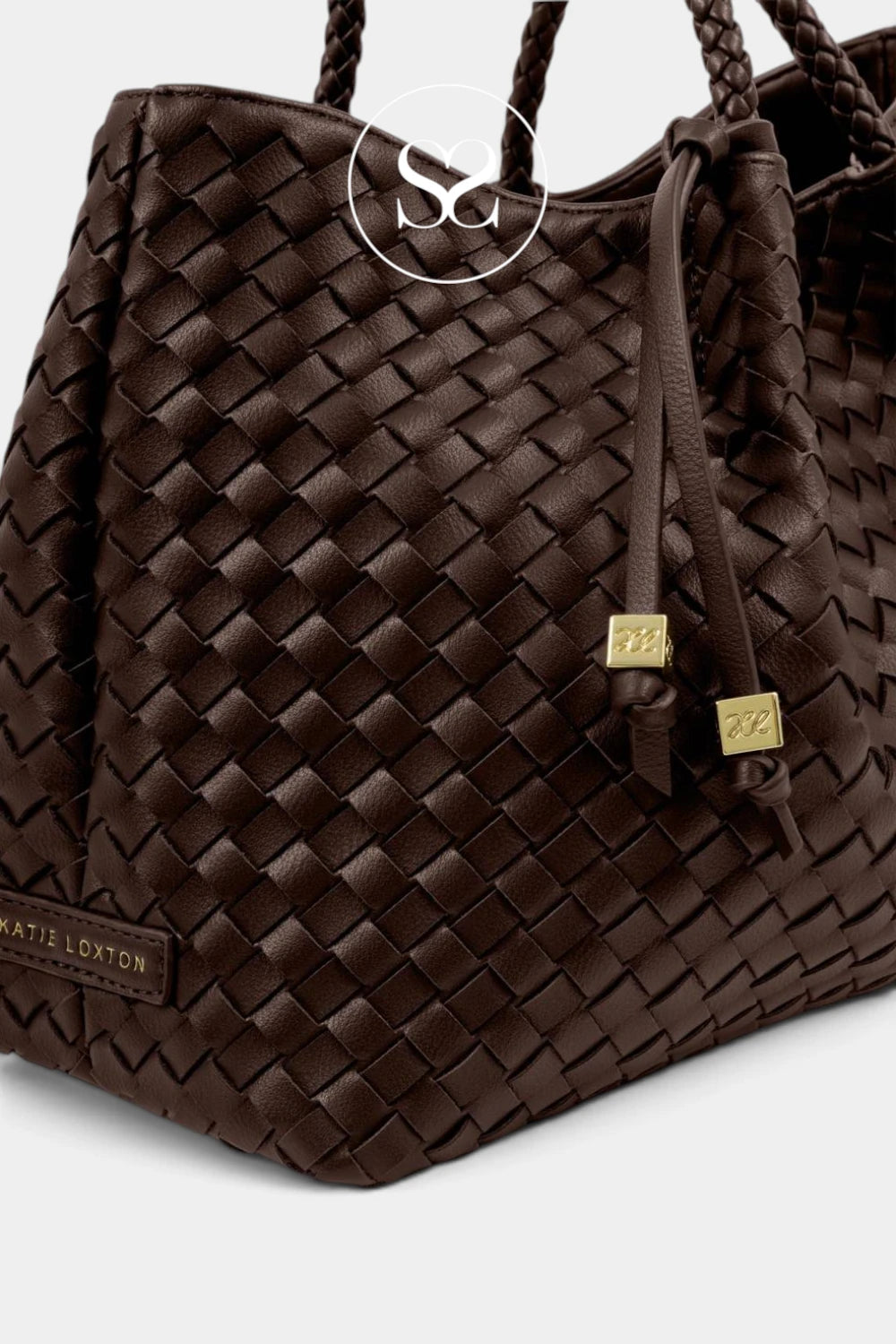A close-up of a dark brown woven leather tote bag with braided shoulder straps, gold-tone hardware
