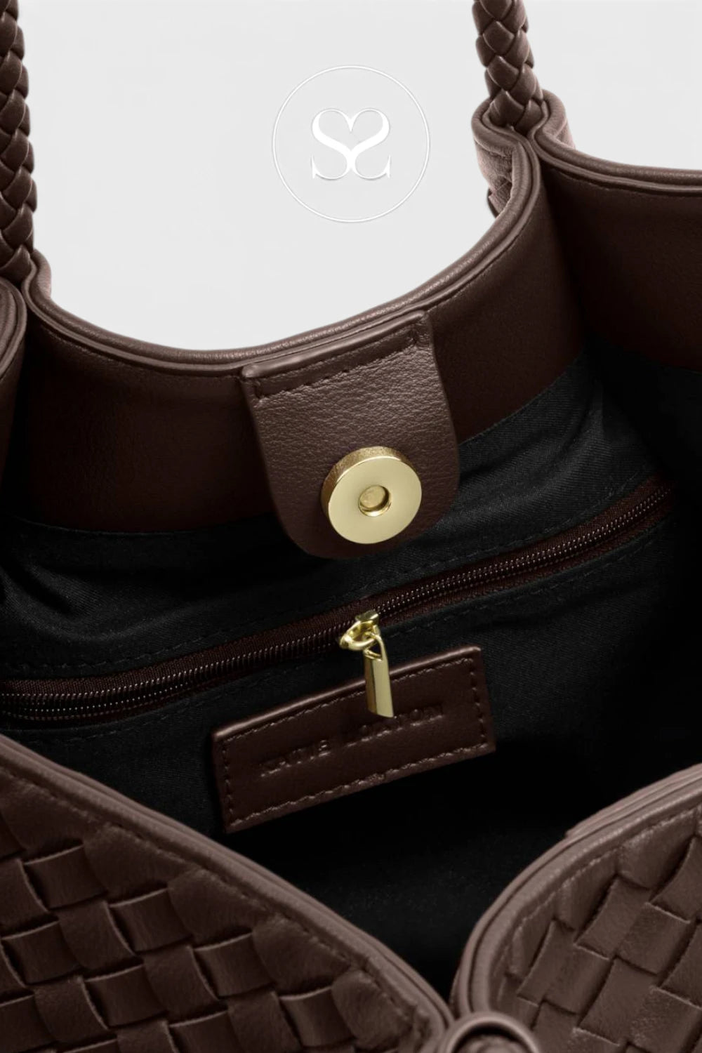 Close-up of a dark brown woven leather handbag showing the interior, black fabric lining, a gold-tone snap button, zipper pull, and a small branded leather tag.