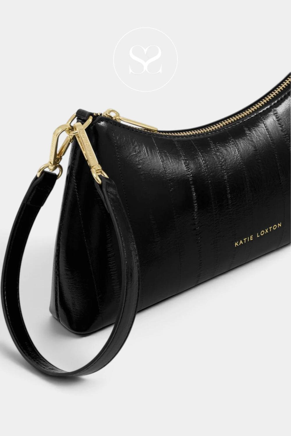 A black textured leather wristlet clutch bag with gold-tone hardware and a gold-embossed 'KATIE LOXTON' logo on the side, shown on a light gray background.