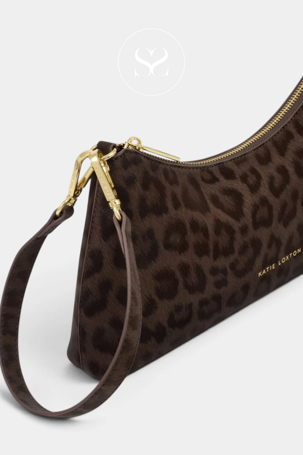 A brown leopard-print wristlet clutch with gold-tone hardware and a matching wrist strap, shown on a light gray background with a faint circular logo watermark above.