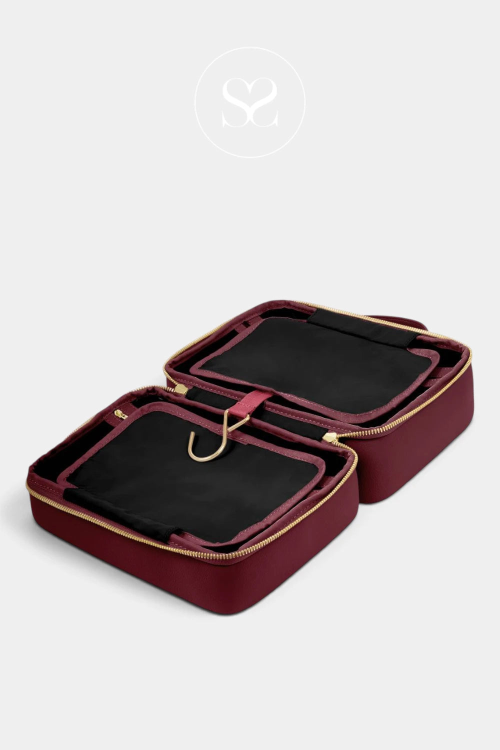A burgundy zippered jewelry organizer case shown open, revealing black velvet interior compartments and gold-tone zipper hardware, photographed on a light gray background.