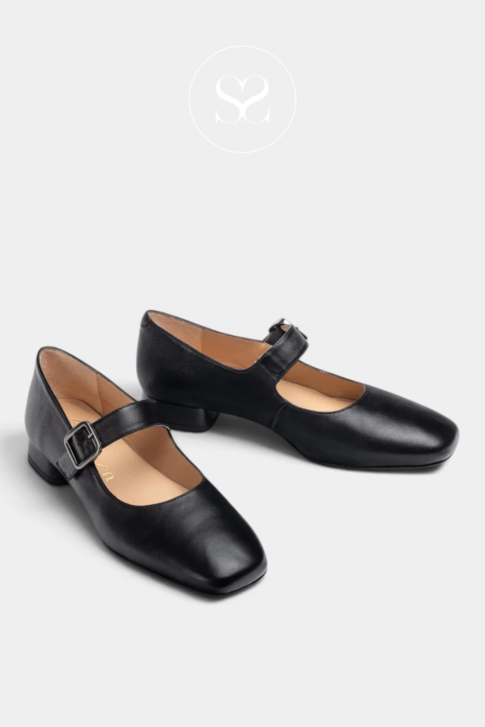 A pair of black leather Mary Jane shoes with square toes and low block heels from Unisa, displayed on a light gray background with a faint Sheneil Shoes brand logo at the top.