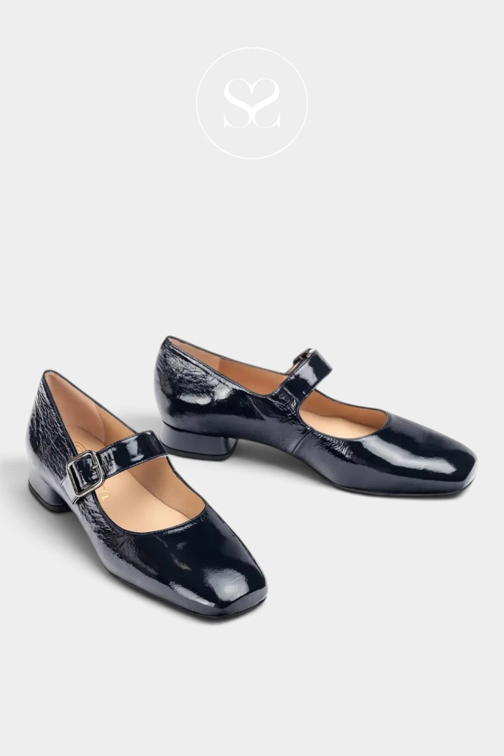 A pair of glossy black Mary Jane block heels with a textured crocodile-embossed pattern on the toe and heel, displayed on a light gray background with a white logo watermark at the top.