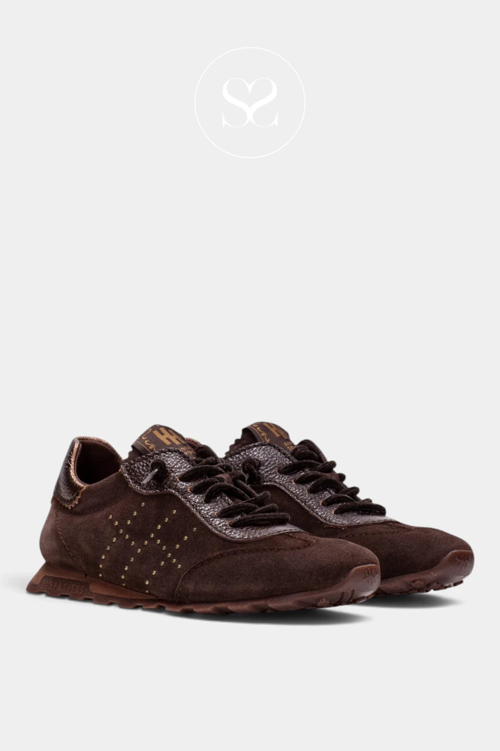 A pair of dark brown suede and leather low-top sneakers with decorative studs on the side, displayed against a light gray background.