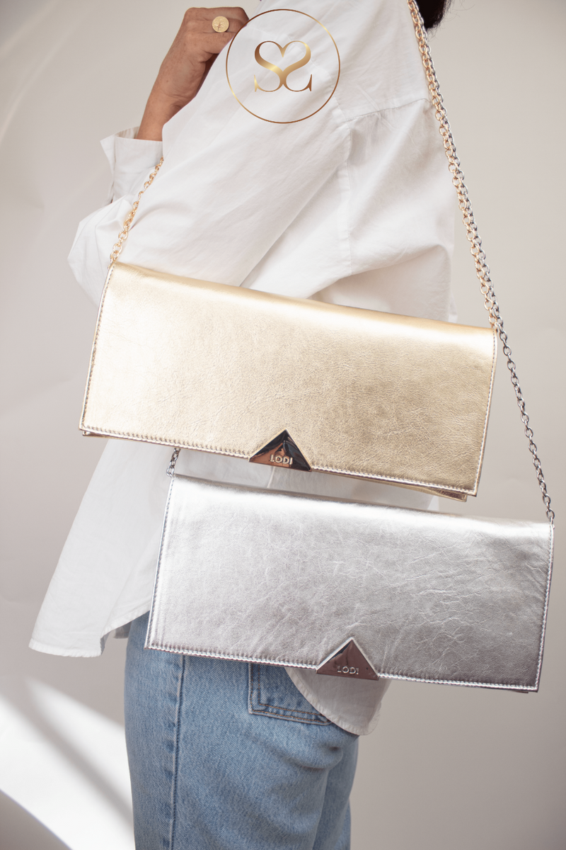 WOMAN WEARING GOLD LODI CLUTCH BAG