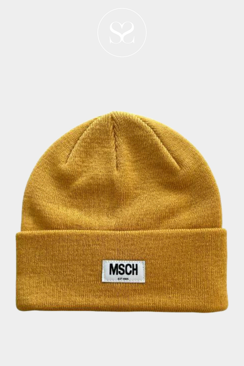 COOL BEANIE STYLE FROM MOSS COPENHAGEN. COMES IN A BEAUTIFUL MUSTARD SHADE WITH A SMALL MSCH BADGE LOGO ON FRONT. MOSS COPENHAGEN MOJO HAT